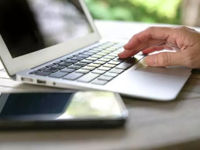 Main d'un homme sur un laptop